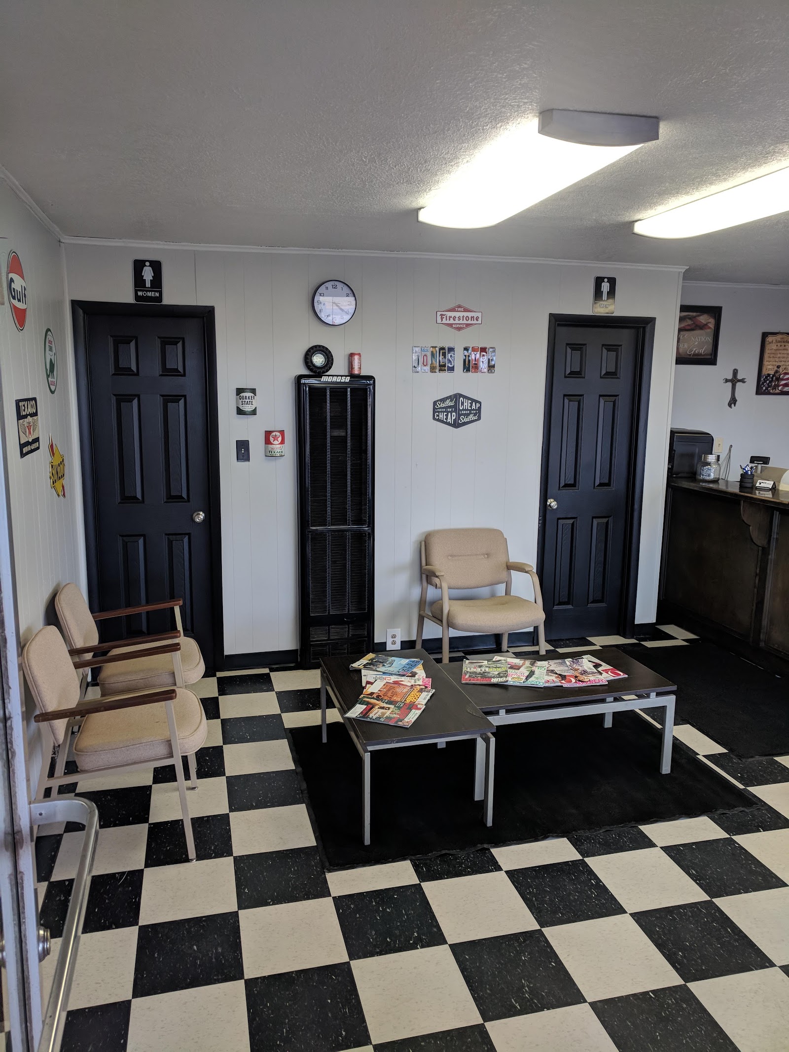 Waiting room with vintage Gulf, Texaco and Firestone signs on a black and white checkered floor